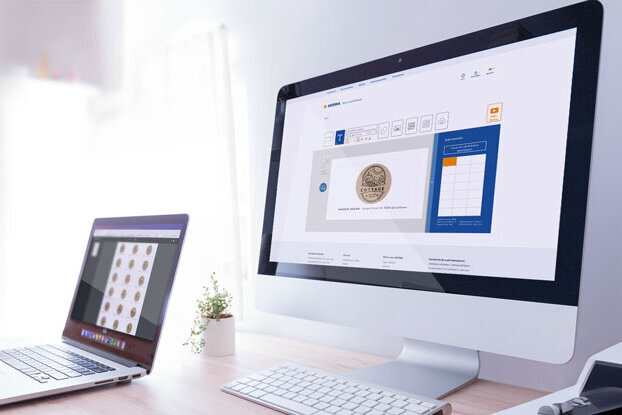To dataskjermar på eit skrivebord, den eine viser eit brukargrensesnitt, den andre ei samling myntar.